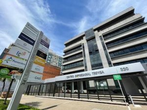 Fachada de centro empresarial com totem listando diversas empresas instaladas no mesmo endereço